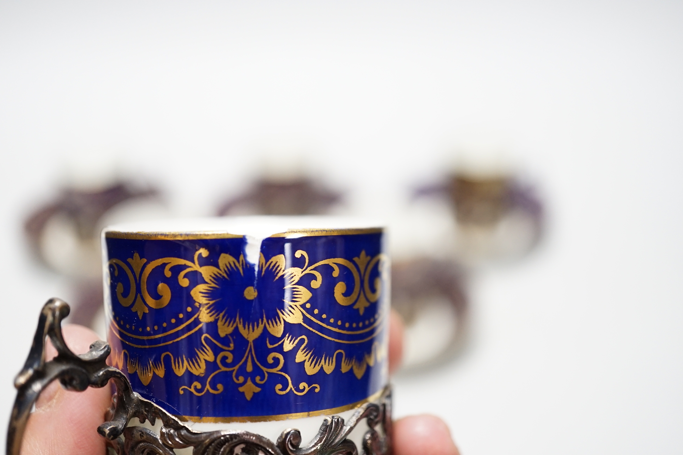 A set of six silver jacketed porcelain cups and saucers